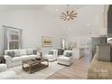 Open living room featuring vaulted ceilings, hardwood floors, and a view into the kitchen at 828 Cabaniss Dr, Shelby, NC 28150