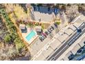Aerial view showing building, parking lot, and swimming pool at 1000 E Woodlawn Rd # 105, Charlotte, NC 28209