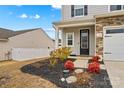 Landscaped front yard with red and yellow plants, and a white fence at 140 Colonial Reserve Ave, Troutman, NC 28166