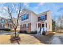 Two-story house with stone and beige vinyl siding, front porch, and American flag at 239 Anvil Draw Pl, Rock Hill, SC 29730