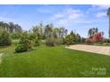 A sprawling backyard with lush green grass, decorative trees and an iron fence at 253 Stone Mountain Way, Denver, NC 28037