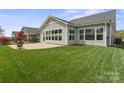 A well-maintained backyard featuring a lush lawn and a paver patio adjoining the home at 253 Stone Mountain Way, Denver, NC 28037