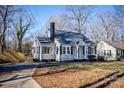 Tan house with gray roof, black shutters, and a paved driveway at 751 N Miller Ave, Statesville, NC 28677