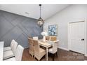 Cozy dining room with wicker chairs, decorative wall panel, and elegant chandelier at 11735 Ridgeway Park Dr, Charlotte, NC 28277