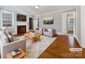 Virtually staged living room featuring hardwood floors and a fireplace at 1215 Neal Hawkins Rd, Gastonia, NC 28056