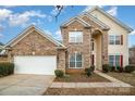 Two story brick home with a white garage door and landscaping at 16737 Winston Oaks Ct # 297, Charlotte, NC 28213