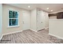 Front entry with wood-look floors, white door, and view of kitchen at 1750 J Julian Ln, Charlotte, NC 28208