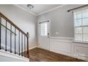 Bright entryway with hardwood floors, staircase, and white wainscoting at 2224 Apple Glen Ln, Charlotte, NC 28269