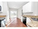 Bright kitchen area featuring granite countertops, stainless sink, and patio doors at 2820 Rosemeade Dr, Monroe, NC 28110