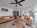 Bright living room with leather sofas, rug, wooden table, and a modern ceiling fan at 5229 Mt Holly Huntersville Rd, Charlotte, NC 28216