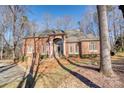 Brick home with welcoming front porch and mature trees at 5424 Amanda Ln, Belmont, NC 28012