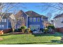 Beautifully landscaped backyard with a well-maintained lawn, mature trees, and a patio area at 626 Lorain Nw Ave, Concord, NC 28027