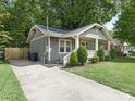 Gray house with a front yard, driveway, and wooden fence at 1317 Downs Ave, Charlotte, NC 28205