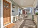 Inviting front porch with wood flooring and charming seating area at 1317 Downs Ave, Charlotte, NC 28205