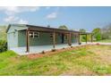 One-story brick house boasts a covered front porch with wooden posts, complemented by well-maintained landscaping at 1410 Mays Chapel Church Rd, Newton, NC 28658