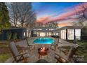 Inviting backyard oasis featuring a sparkling pool, fire pit, and patio seating at 516 Mammoth Oaks Dr, Charlotte, NC 28270