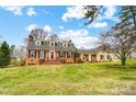 Lovely brick home with dormer windows, a well-kept lawn, and a cozy porch for relaxing outdoors at 109 Chanticleer Ct, Charlotte, NC 28214