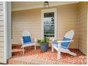 Cozy front porch with white Adirondack chairs and a charming brick floor at 109 Chanticleer Ct, Charlotte, NC 28214