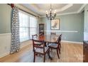 Elegant dining room featuring hardwood floors and a formal dining table at 13836 Ballantyne Meadows Dr, Charlotte, NC 28277