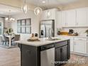 Modern kitchen with an island, stainless steel appliances, and white shaker cabinets at 205 Cliffwood Nw St # B-2, Concord, NC 28027