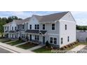 View of townhomes with manicured lawns, sidewalks, and convenient parking spaces at 205 Cliffwood Nw St # B-2, Concord, NC 28027