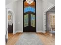 Grand foyer featuring a decorative glass-paneled door, hardwood floors, and an arched doorway at 1024 Adkins Rd, York, SC 29745