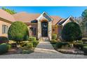 Beautiful brick home featuring an arched stone entryway, a paved walkway, and lush manicured greenery at 1024 Adkins Rd, York, SC 29745