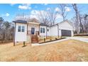 Charming white home featuring a two-car garage, wooden porch, and a well-manicured lawn at 118 Stockbridge Ln, Statesville, NC 28677
