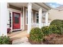 Red front door entry with white columns and lush landscaping at 135 Yellowbell Rd, Mooresville, NC 28117