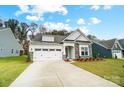 Two-story home with white and stone exterior and a two-car garage at 4003 Grace Pointe Dr # 99, Wesley Chapel, NC 28079