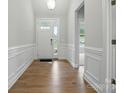 Inviting foyer boasts beautiful wall trim, wood flooring, and a view into the adjacent living space at 4003 Grace Pointe Dr # 99, Wesley Chapel, NC 28079