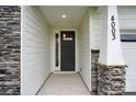 The home's front entrance is framed by stone pillars and white siding, providing a stylish and welcoming facade at 4003 Grace Pointe Dr # 99, Wesley Chapel, NC 28079