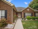 Inviting front entrance with a well-manicured walkway leading to a charming doorway and blossoming flowers at 416 Zelkova St, York, SC 29745
