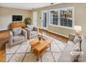 Virtually staged living room with wood floors, neutral walls, and comfy seating at 8003 Regent Park Ln, Charlotte, NC 28210