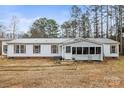 Exterior front view of a cozy single-story home with white siding, shuttered windows, and a quaint enclosed porch at 127 Mystic Ct, Troutman, NC 28166