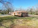 Ranch home with side yard, landscaping, and partial pool view at 1515 Hasty Rd, Marshville, NC 28103