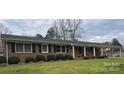 Ranch style brick home with covered porch and well-manicured lawn at 549 Dairy Rd, Troy, NC 27371