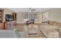Cozy living room with wood floors, neutral paint, ceiling fan, and plenty of natural light at 549 Dairy Rd, Troy, NC 27371