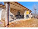 Inviting front porch with brick columns, seating area, and decorative sunflower flag at 1304 Cambridge Dr, Shelby, NC 28152