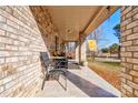 Cozy covered front porch featuring brick pillars, tiled flooring, and a comfy seating area at 1304 Cambridge Dr, Shelby, NC 28152