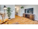 Living room with hardwood floors, media console, and access to hallway at 1309 Winding Branch Ct, Charlotte, NC 28216