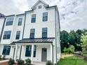 Stylish three-story townhouse featuring a white exterior with black accents and a covered front porch at 15306 Ballancroft Pkwy # 21, Charlotte, NC 28277