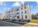 Row of three story townhouses with white siding, gray stairs and landscaping at 15306 Ballancroft Pkwy # 21, Charlotte, NC 28277