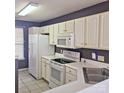 Bright kitchen featuring white cabinets, a microwave, and a corner sink at 16740 Timber Crossing Rd, Charlotte, NC 28213