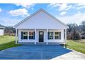 White exterior home with a covered porch and a two-car driveway at 1715 Pope Ave, Gastonia, NC 28052