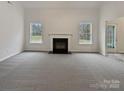 Spacious living room with a fireplace and neutral carpeting at 2154 Pheasant Glen Rd, Charlotte, NC 28214