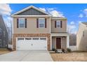 Two-story house with tan siding, brown door, and white garage door at 2262 Redstone Dr, York, SC 29745