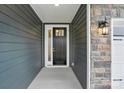 Close-up of the elegant front door, complemented by stylish stonework and modern lighting at 4005 Grace Pointe Dr # 100, Wesley Chapel, NC 28079