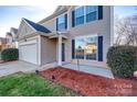 Two-story house with taupe vinyl siding, and a front entrance with a storm door at 4649 Maple Crest Pl, Harrisburg, NC 28075