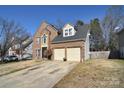 Two-story brick home with a two-car garage and manicured lawn at 5921 Marshbank Ln, Charlotte, NC 28269